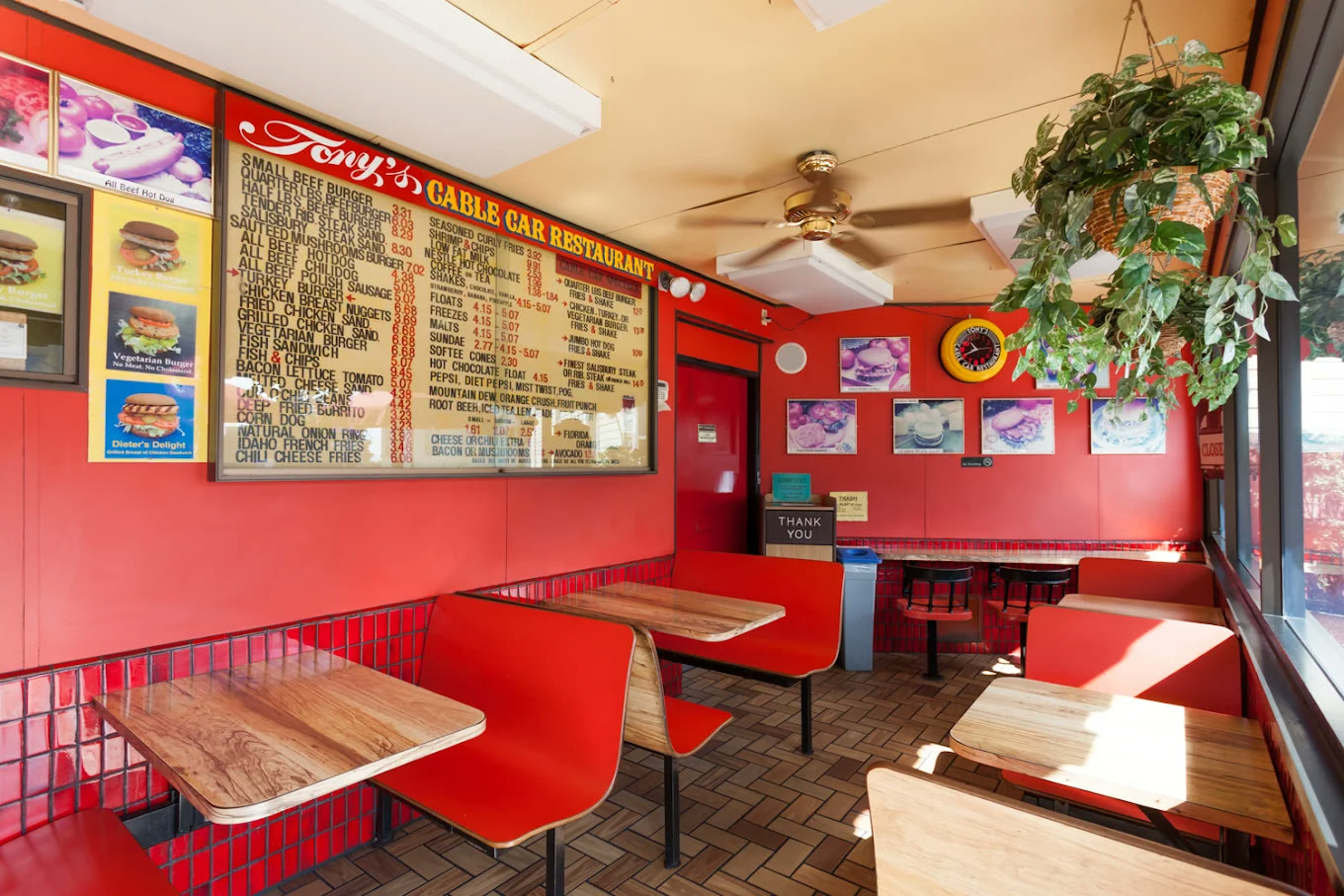Inside Tony’s Cable Car: the letter-board menu under the Tony’s Cable Car Restaurant sign, red walls and red tile, and red booths at wood-grain tables