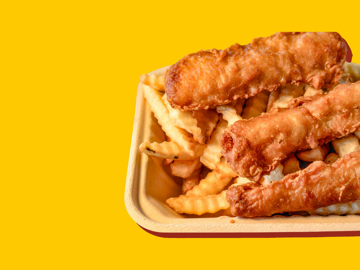 Three pieces of battered cod on crinkle-cut fries in a paper tray